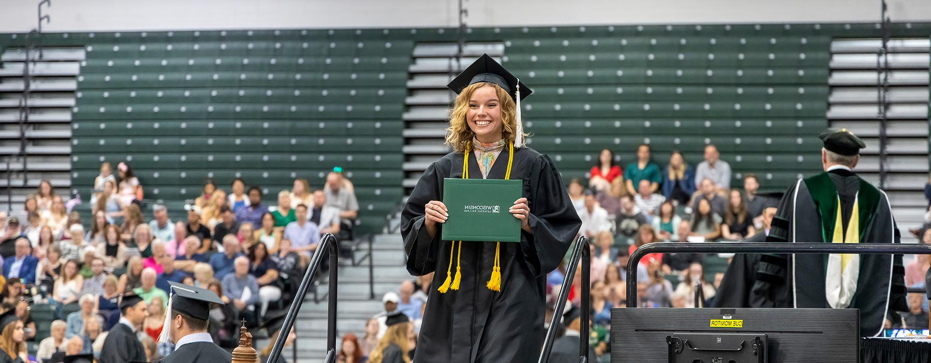 Graduate on stage with diploma at commencement